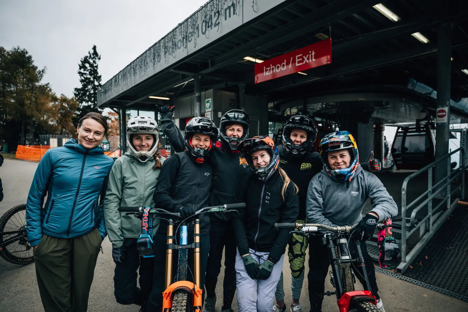 Skupina kolesark v opremi za gorsko kolesarjenje z downhill kolesi pred žičnico